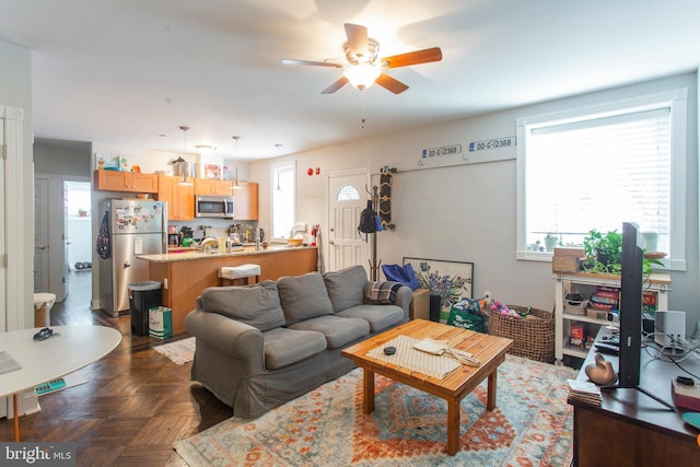 living room featuring dark parquet flooring and ceiling fan