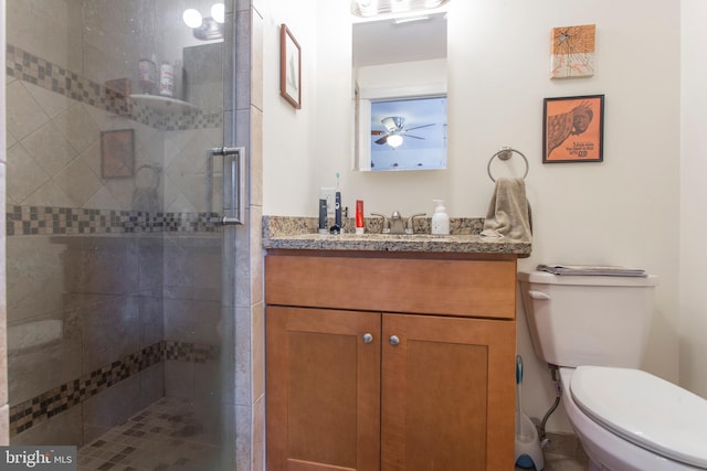 bathroom featuring vanity, ceiling fan, toilet, and a shower with door