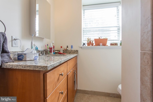 bathroom featuring tile patterned flooring, vanity, and toilet