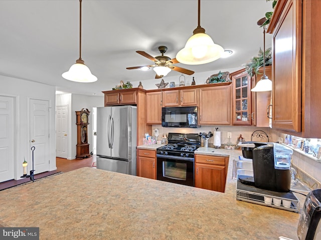 kitchen featuring black appliances, pendant lighting, and light wood-type flooring