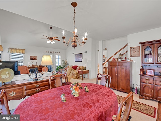 dining area featuring vaulted ceiling and ceiling fan with notable chandelier