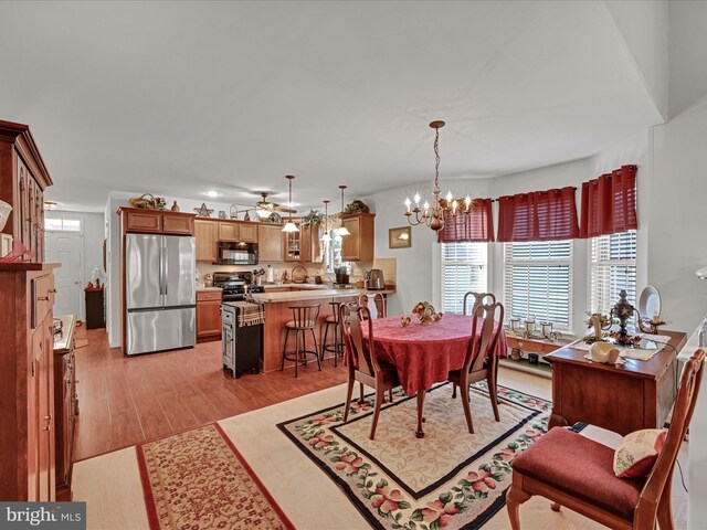 dining space featuring light wood-type flooring, a chandelier, and sink