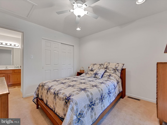 carpeted bedroom featuring ensuite bathroom, ceiling fan, a closet, and sink