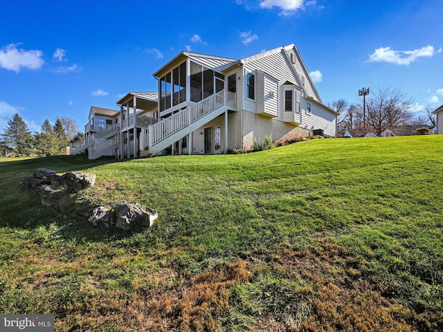 view of side of home with central air condition unit, a lawn, and a sunroom