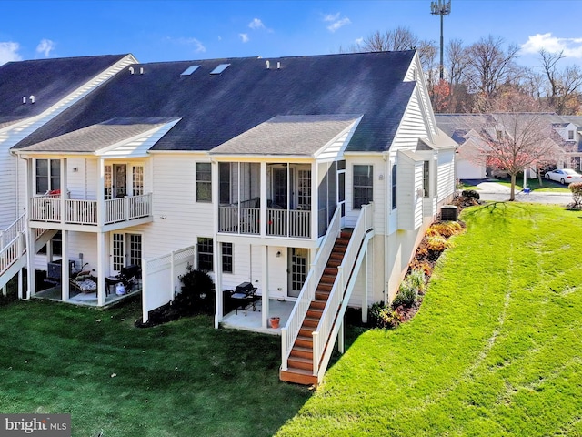 rear view of property featuring a yard, cooling unit, and a patio area