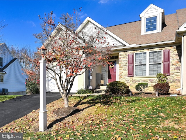 view of front of home featuring a front yard and central AC