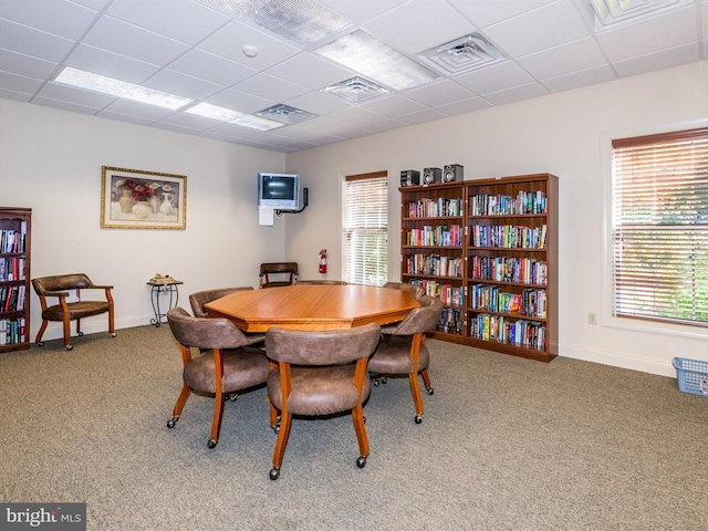 carpeted dining room with a drop ceiling