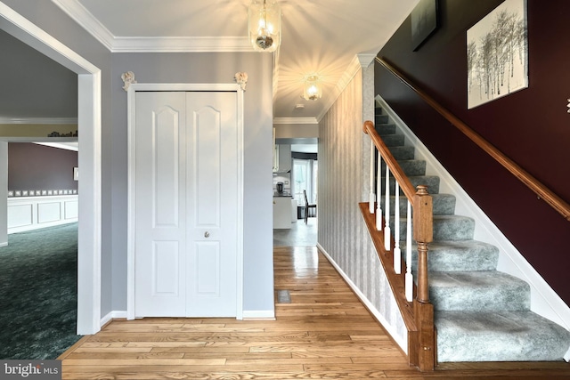 stairway with hardwood / wood-style flooring and crown molding