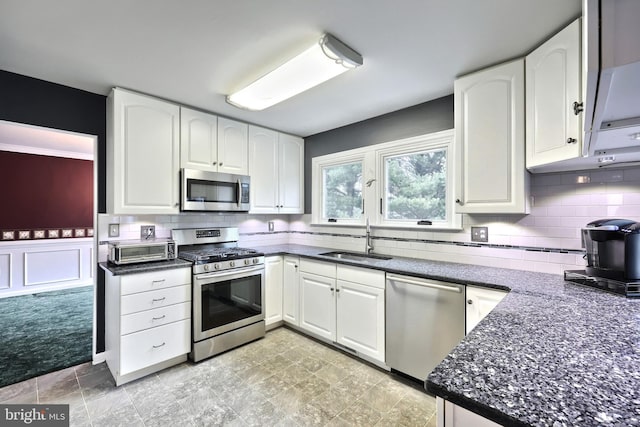 kitchen with backsplash, white cabinetry, sink, and stainless steel appliances