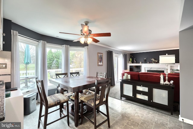 dining space with ceiling fan and crown molding