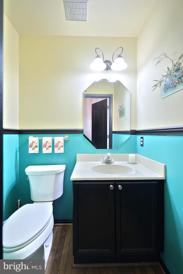 bathroom featuring wood-type flooring, vanity, and toilet