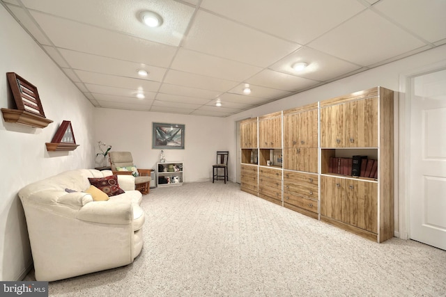 carpeted living room with a paneled ceiling