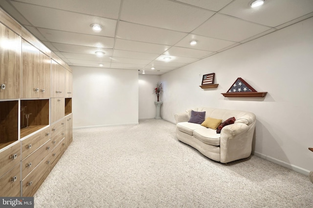 living area featuring light carpet and a drop ceiling