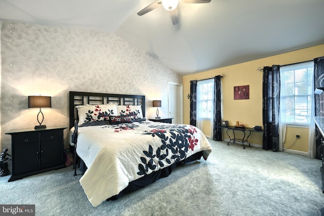 bedroom featuring carpet, vaulted ceiling, multiple windows, and ceiling fan