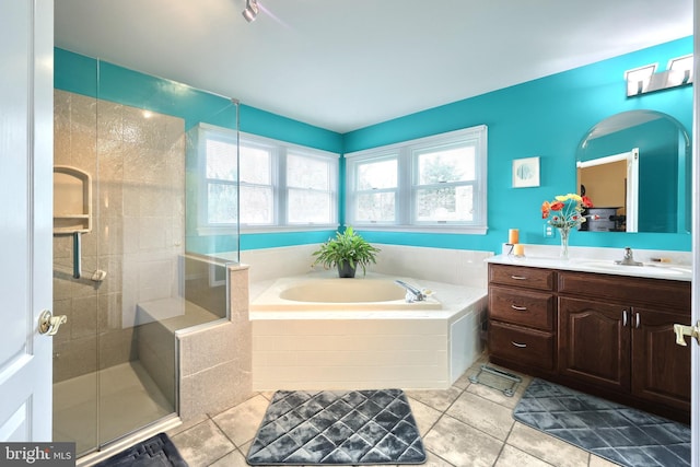 bathroom featuring tile patterned flooring, shower with separate bathtub, and vanity