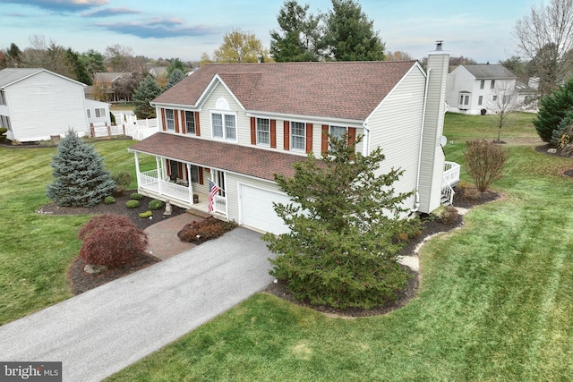 view of front facade with covered porch, a garage, and a front lawn