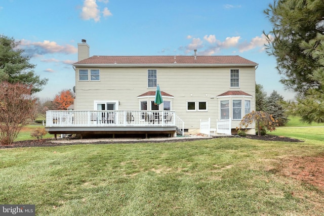 rear view of house featuring a deck and a lawn