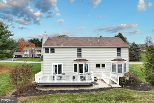 rear view of property with a lawn and a wooden deck