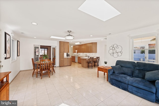 living room with light tile patterned flooring and a skylight