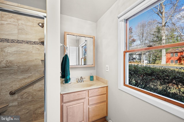 bathroom with vanity, tiled shower, and plenty of natural light