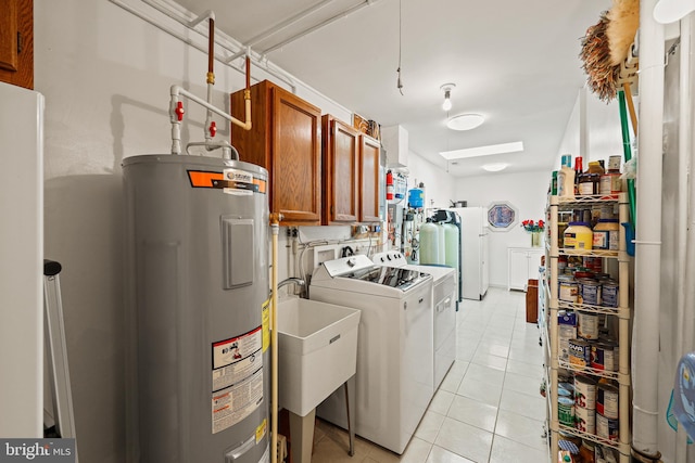 laundry room with light tile patterned flooring, separate washer and dryer, water heater, cabinets, and sink