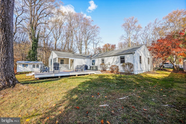 rear view of house with a deck, a lawn, and central AC unit