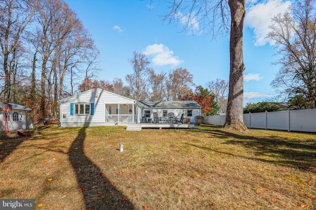 back of property featuring a lawn and a deck