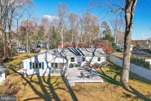 rear view of property with a yard and a deck