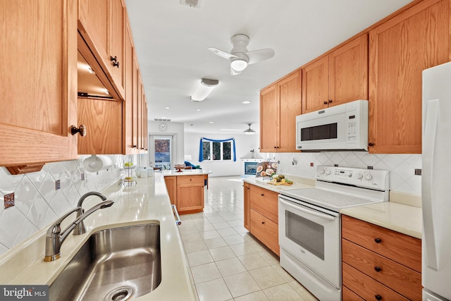 kitchen with sink, kitchen peninsula, light tile patterned floors, white appliances, and decorative backsplash