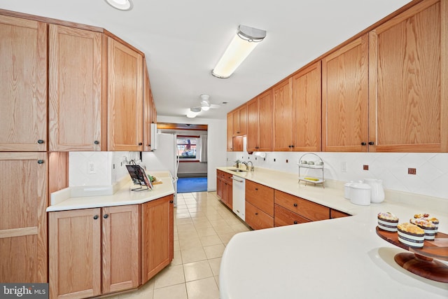 kitchen with light tile patterned flooring, backsplash, sink, and white dishwasher