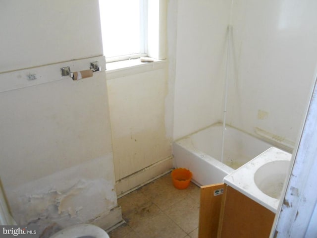 bathroom featuring a washtub and vanity