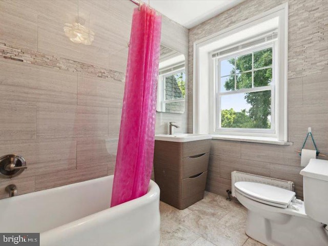 full bathroom featuring shower / bath combo, vanity, tile walls, radiator heating unit, and toilet