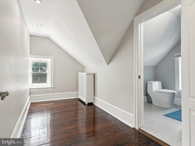 additional living space featuring dark hardwood / wood-style flooring and vaulted ceiling