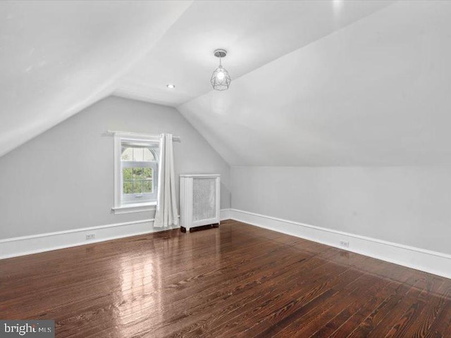 additional living space with dark hardwood / wood-style flooring and vaulted ceiling