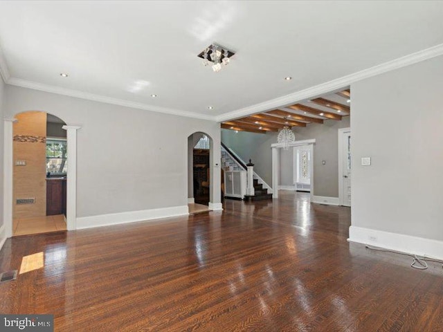 unfurnished living room featuring beamed ceiling, dark hardwood / wood-style flooring, ornamental molding, and an inviting chandelier