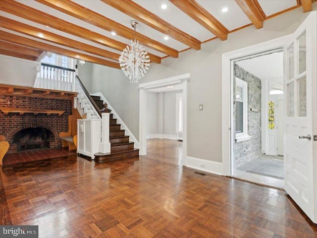 unfurnished living room with dark parquet flooring, beamed ceiling, a chandelier, and a brick fireplace