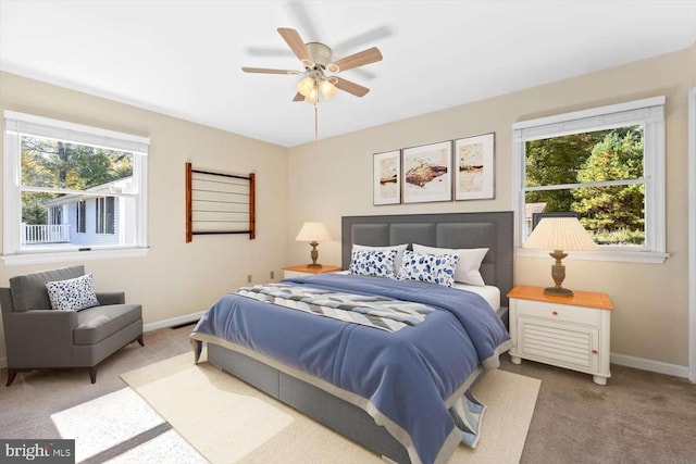 bedroom featuring carpet, ceiling fan, and multiple windows