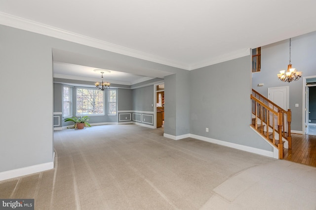 carpeted living room featuring a chandelier and ornamental molding