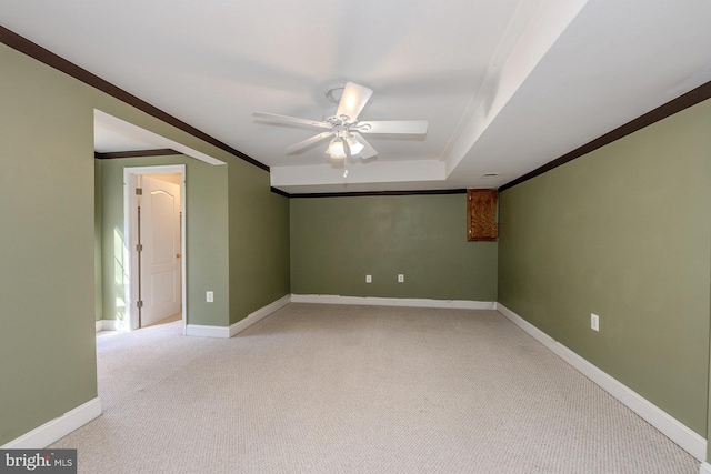 carpeted spare room with ornamental molding, ceiling fan, and a raised ceiling