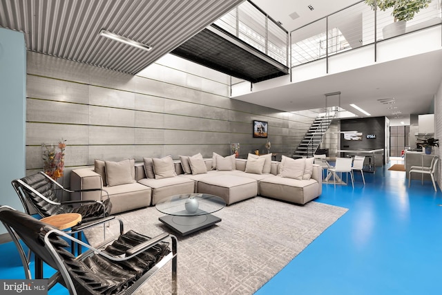 living room featuring concrete flooring and a high ceiling