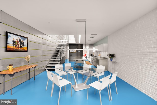 dining area featuring concrete flooring and brick wall