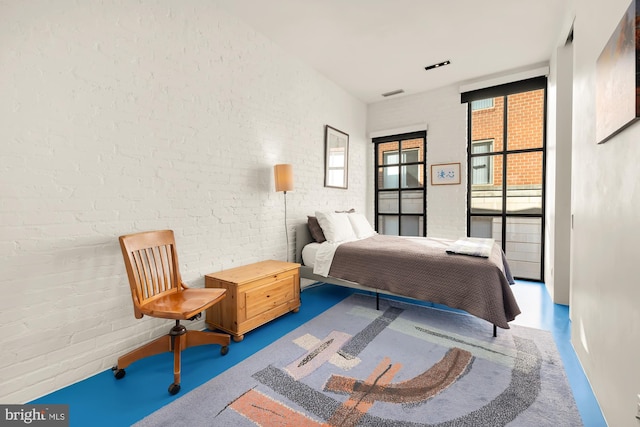 bedroom with brick wall and concrete floors