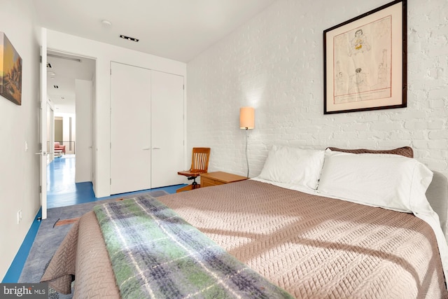 bedroom with concrete flooring and a closet