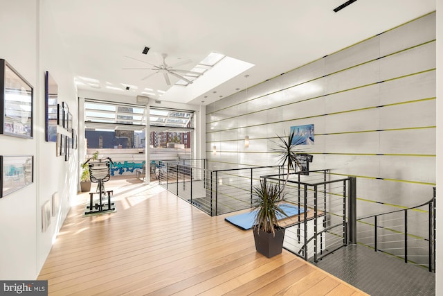 hall featuring hardwood / wood-style floors and a skylight