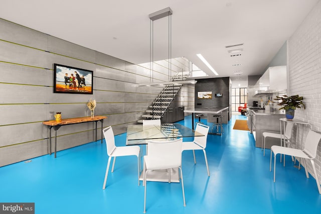 unfurnished dining area featuring concrete flooring and a skylight