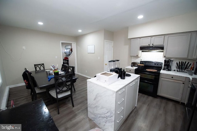 kitchen with gray cabinetry, backsplash, an island with sink, electric range, and dark wood-type flooring