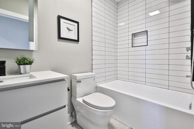 full bathroom with vanity, tiled shower / bath combo, and toilet