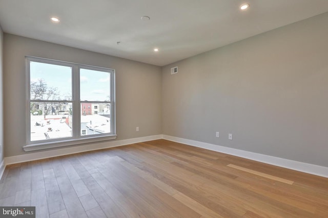 empty room with light hardwood / wood-style flooring