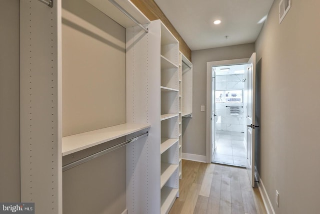 walk in closet with light wood-type flooring