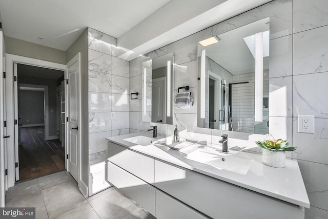 bathroom featuring vanity and tile walls